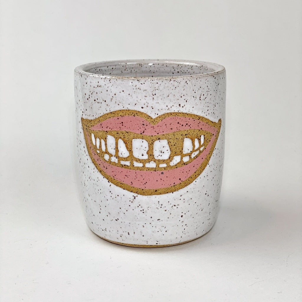 Hot Pink lipstick colored mouth mug with a gap tooth in the upper row of teeth, white gloss glaze over speckled tan clay